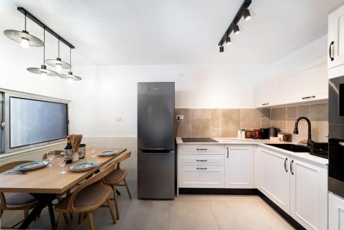 a kitchen with a table and a black refrigerator at אשראם-Ashram Eilat in Eilat