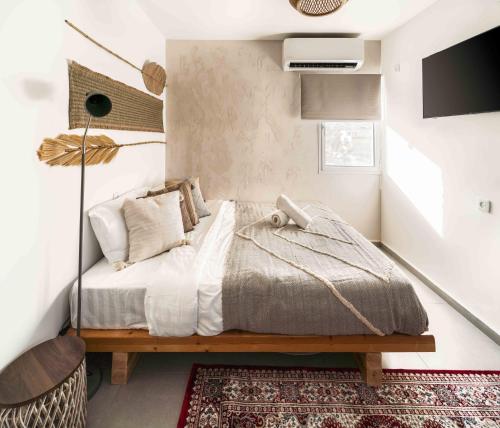 a bedroom with a bed and a tv on a wall at אשראם-Ashram Eilat in Eilat