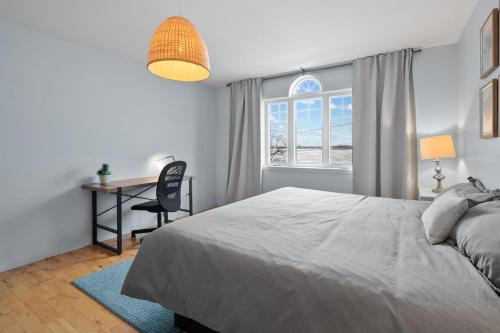 a bedroom with a bed and a desk and a window at A Getaway on Lake Champlain in Venise-en-Québec