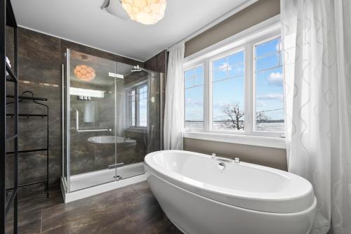 a white bath tub in a bathroom with a window at A Getaway on Lake Champlain in Venise-en-Québec