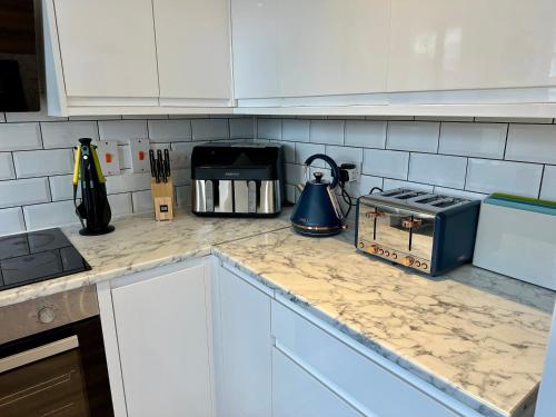 a kitchen counter top with a tea kettle on it at Serviced Accommodation, 3 Bed, allocated off road parking, Contractor Ready in Bedford