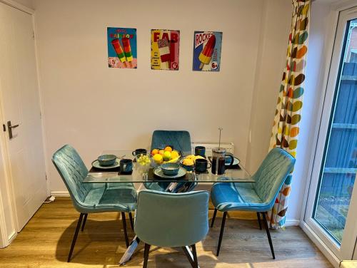 a dining room with a table with chairs and fruit on it at Serviced Accommodation, 3 Bed, allocated off road parking, Contractor Ready in Bedford
