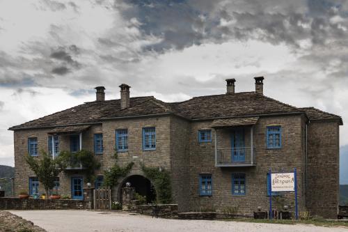 an old brick building with a sign in front of it at Petroto in Fragkades