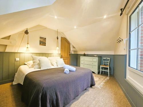 a bedroom with a large bed and a dresser at La Grive - Petit nid douillet proche de la plage in Étretat