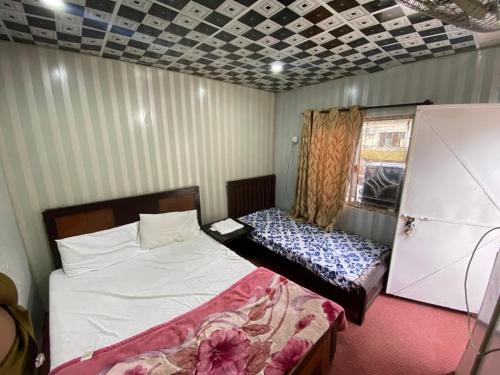 a room with two beds and a window and a bedskirts at Getaway lodge Guesthouse in Islamabad
