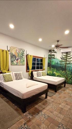 two beds in a room with yellow curtains at Finca El Monasterio in Rivas