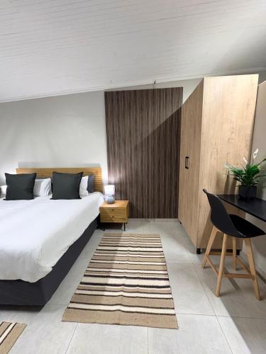 a bedroom with a large bed and a desk at Green Haven Waitara in Tzaneen