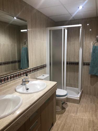 a bathroom with a sink and a shower and a toilet at Atelier de lujo lucena in Lucena
