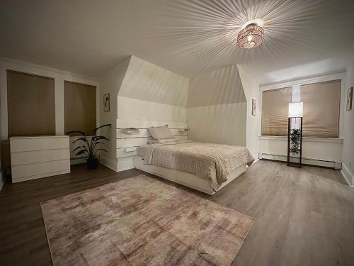 a large bedroom with a bed and a lamp at Blatchley Rooms by Yale in New Haven