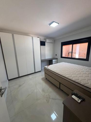 a large bedroom with a bed and a window at Casa da Palmeira com Piscina in Piratuba