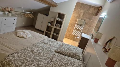 a small bedroom with a bed and a bathroom at Love room- Le Cocon Osé in Autun