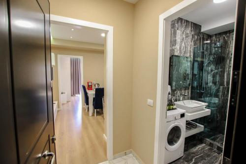 a bathroom with a sink and a washing machine at Brilant Luxury Apartment in Gjirokastër