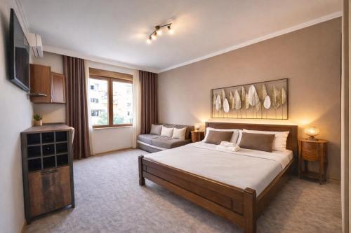 a hotel room with a bed and a couch at Podgorica City Center Apartment Main Boulevard View Free Wi-Fi in Podgorica