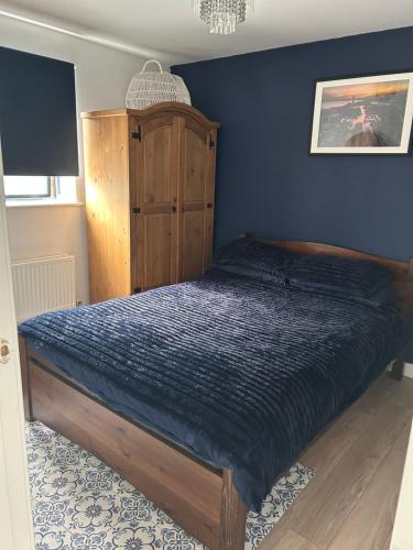 a bedroom with a bed and a wooden cabinet at Swansea Waterfront in Swansea