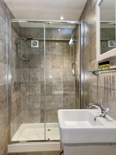 a bathroom with a shower and a sink at Sibton White Horse Inn in Saxmundham