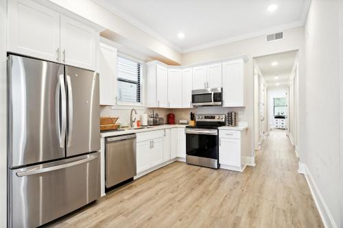 a kitchen with white cabinets and a stainless steel refrigerator at 2 Mi to Dtwn Jazz Clubs and Soul Food! NOLA Home in New Orleans