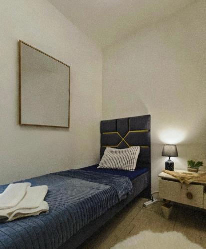 a bedroom with a blue bed with a picture on the wall at Royal rooms Ajman in Ajman