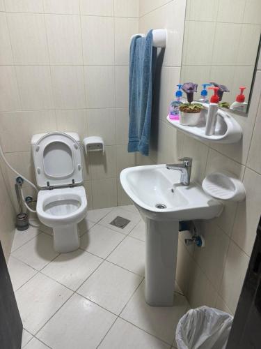a bathroom with a toilet and a sink at Royal rooms Ajman in Ajman