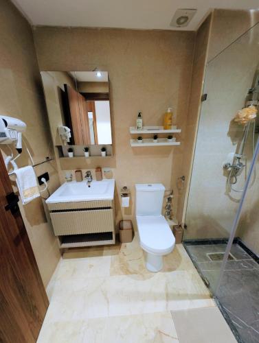 a bathroom with a toilet and a sink at Pool view apartment, beach access, nature & quiet in Mansouria