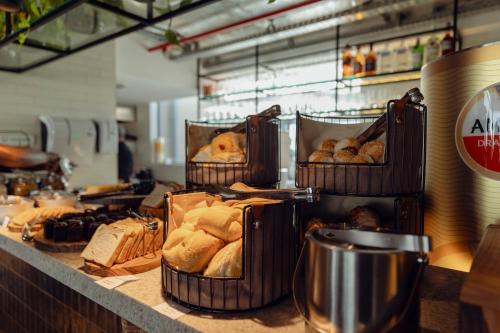 a bakery counter with baskets of bread and pastries at Motto By Hilton Recife in Recife