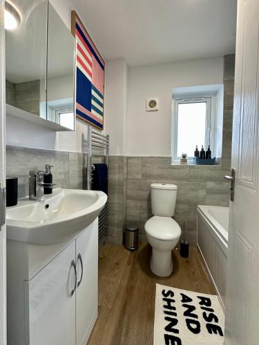 a bathroom with a white sink and a toilet at Serviced Accommodation, 3 Bed, allocated off road parking, Contractor Ready in Bedford