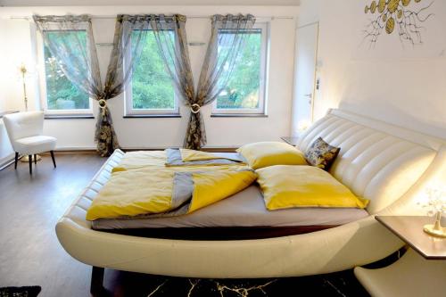 a bed with yellow pillows on it in a bedroom at Designer Apartement mit Kamin in Hartberg