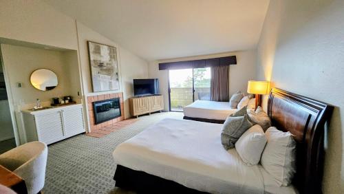 a hotel room with two beds and a television at Adobe Inn in Carmel