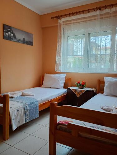 two beds in a small room with a window at Katerina Apartments in Flogita