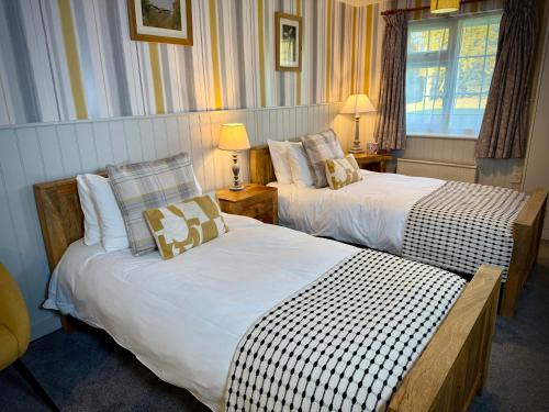a hotel room with two beds and a window at Sibton White Horse Inn in Saxmundham