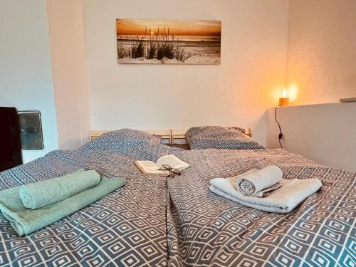a bed with towels and books on top of it at Ferienwohnung momentglücklich in Eggingen in Eggingen