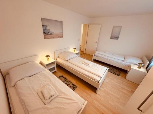 a room with two beds and two tables in it at 3-Room Apartment Up to 5 Guests Family Business Free WiFi Netflix Sky DAZN Disney Plus 1000 International TV Channels in Wynau