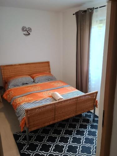 a bedroom with a bed with an orange and blue comforter at Casa Padurarului in Ocnele Mari