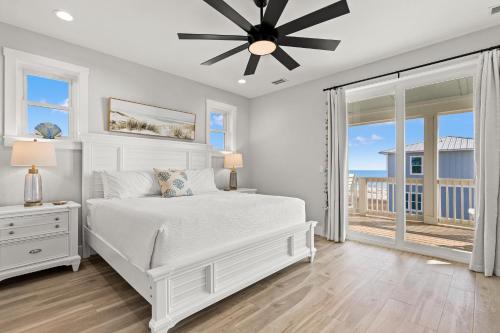 a bedroom with a white bed and a ceiling fan at Pet Friendly Beach House with Private Pool - Bella View in Port Saint Joe