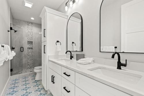 a white bathroom with two sinks and a shower at Pet Friendly Beach House with Private Pool - Bella View in Port Saint Joe