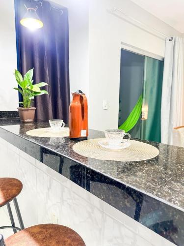 a kitchen counter with two plates and a kettle on it at APË GOLD NO CENTRO DA CIDADE COM AR E CAMA KINg in Formosa