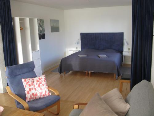 a living room with a bed and a chair at Fuglevænget in Hundested