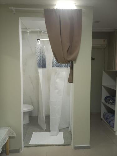 a bathroom with a shower curtain and a toilet at Pousada Romelandia in Romelândia