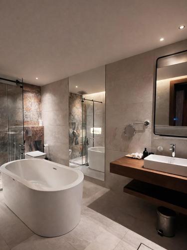 a bathroom with a tub and a sink and a shower at Ramla Resort in Riyadh