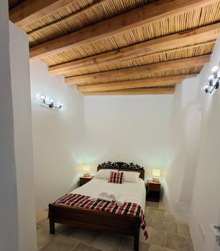 a bedroom with a bed and wooden ceilings at Cecilia Traditional House-Suites in Kalopanayiotis