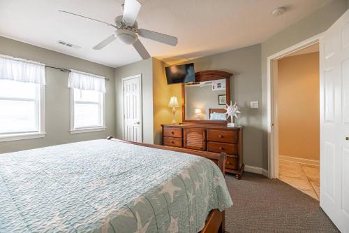 a bedroom with a bed and a dresser and a ceiling fan at Serenity in Nags Head - MP 11, Oceanfront, Ocean View, Pool, Hot Tub, Pets OK, YR Flex Stays in Nags Head