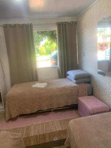 a bedroom with two beds and a window at Pousada Romelandia in Romelândia