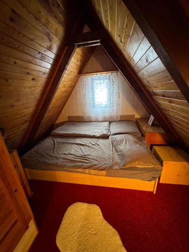 a small bed in a wooden attic room at chata u Ondrucha in Tři Studně