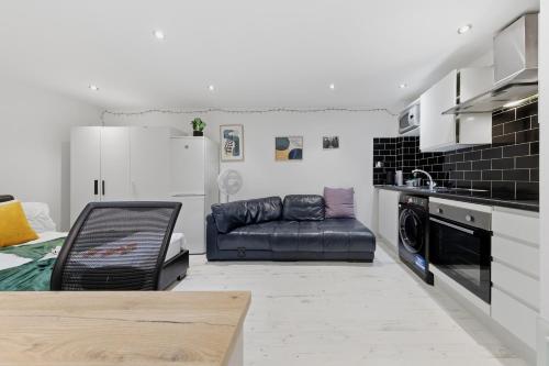 a living room with a couch in a kitchen at Studio Flat in Stepney-Limehouse - Central London in London
