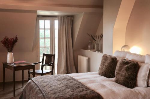 a bedroom with a bed and a table and a window at CASAMAAS in Les Basses Masures