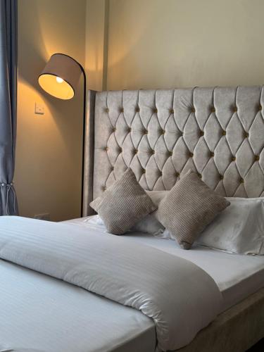 a bed with two pillows on top of it at TMT Homes in Nairobi