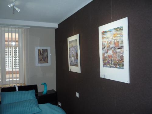 une chambre avec un lit et des tableaux au mur dans l'établissement Gîte Cathédrale Waldner de Freundstein Label "Clévacances", à Strasbourg