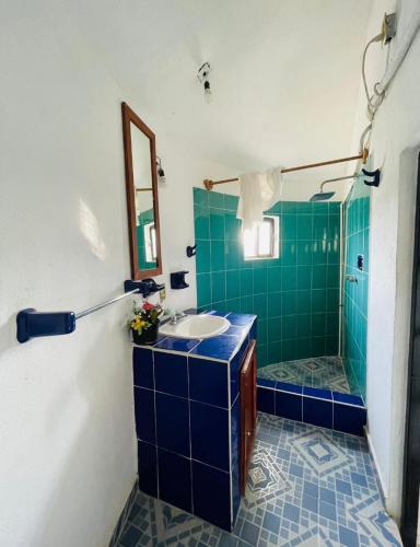 a blue tiled bathroom with a sink and a shower at Rincón San Jerónimo in Tamasopo