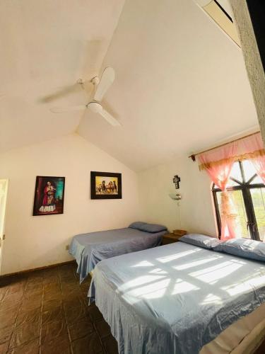 a bedroom with two beds and a ceiling fan at Rincón San Jerónimo in Tamasopo