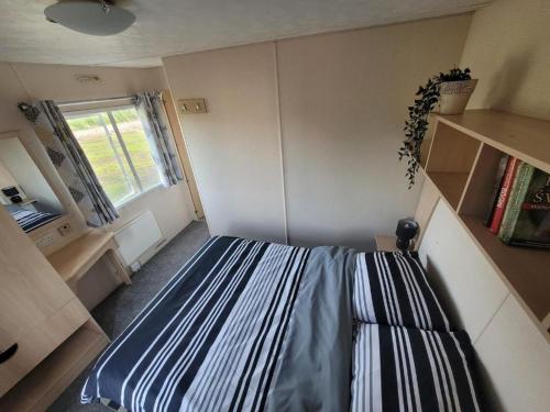 a small room with a bed and a window at Domki nad Szóstakiem in Orzechowo