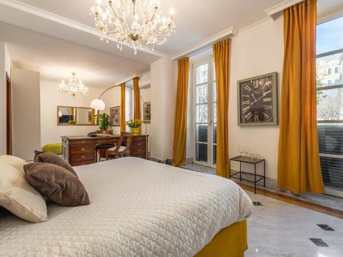 a bedroom with a bed and a desk and a chandelier at Relais La Lanterne in Cagliari